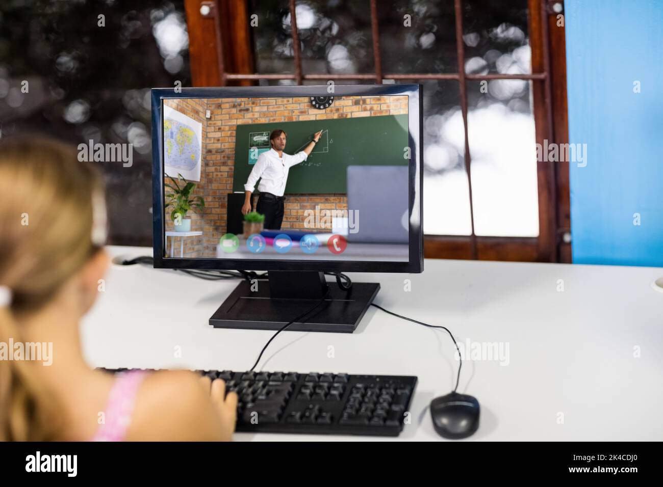 Female student having a video call with male teacher on computer at ...