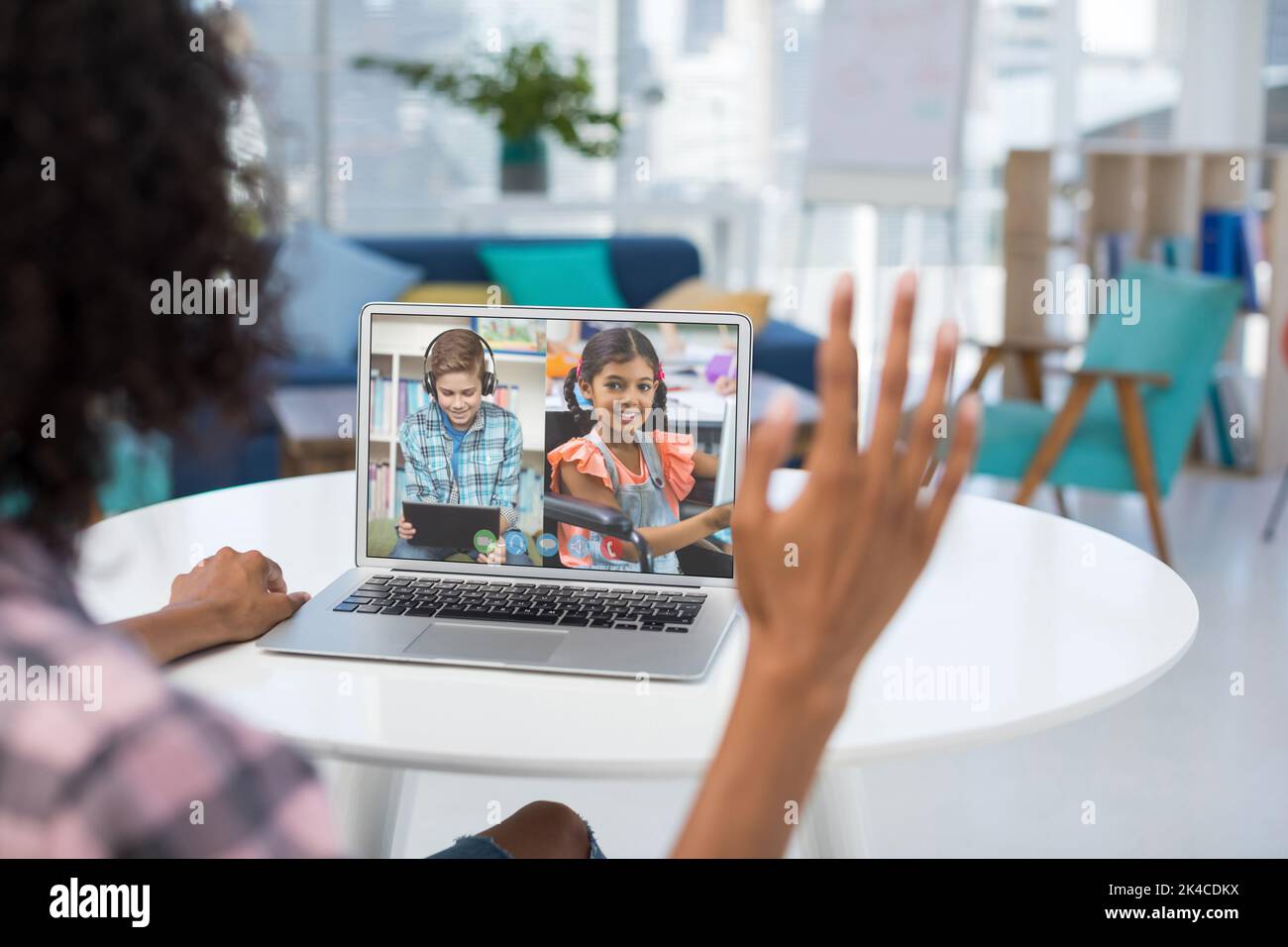 Female teacher having a video conference with male and female student ...