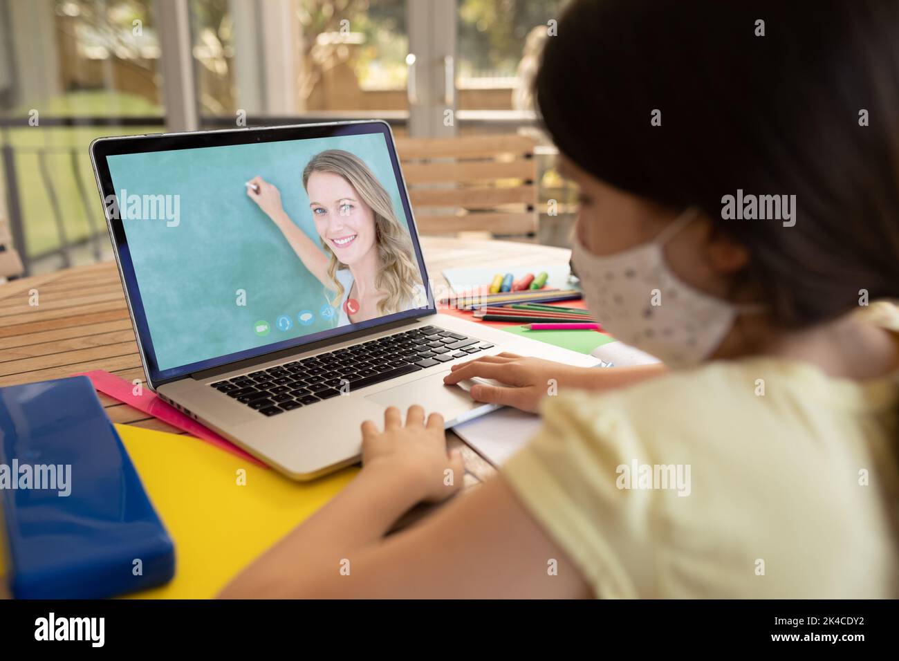 Female student wearing face mask having a video call with female ...