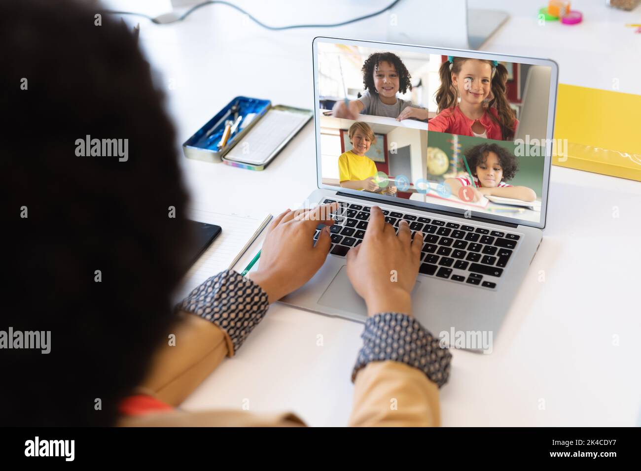 Female teacher having a video conference with multiple students on ...