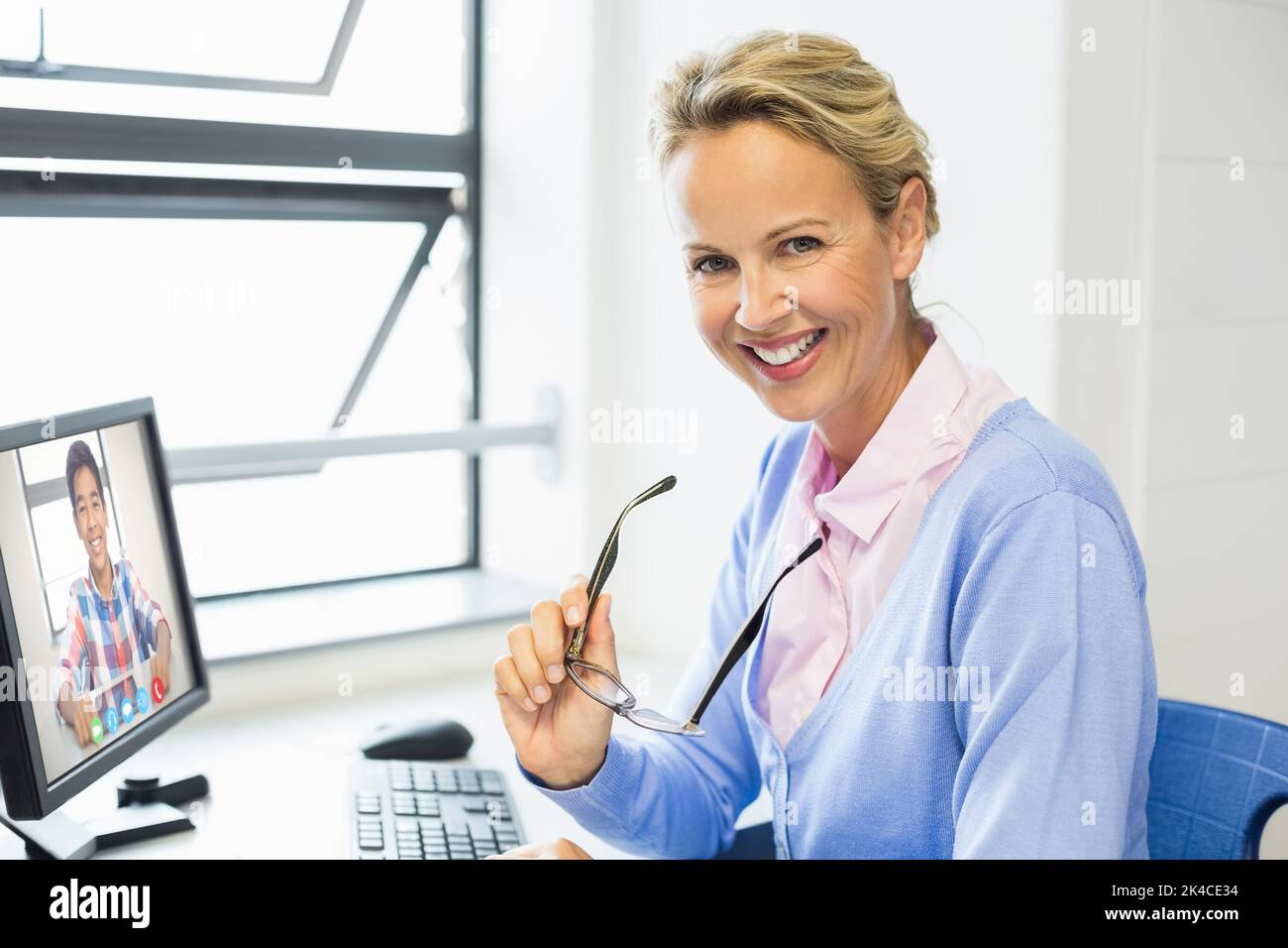 Portrait of female teacher having a video call with male student on ...