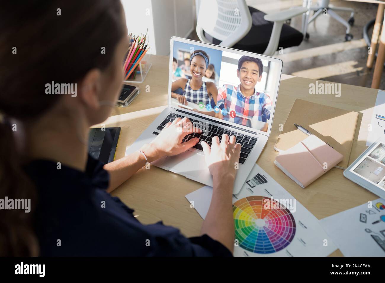Female teacher having a video conference with male and female students ...