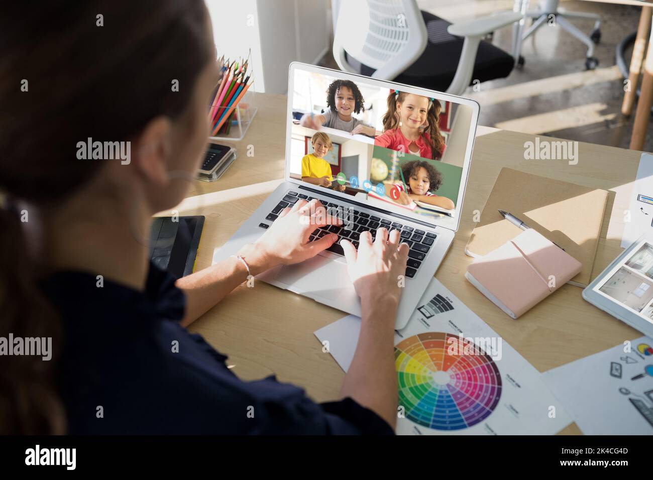 Female teacher having a video conference with multiple students on ...