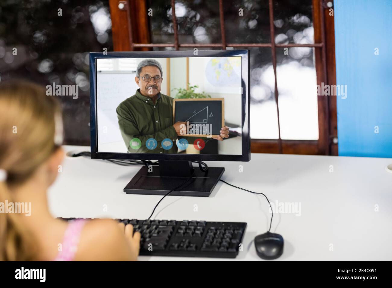 Female student having a video call with male teacher on computer at ...