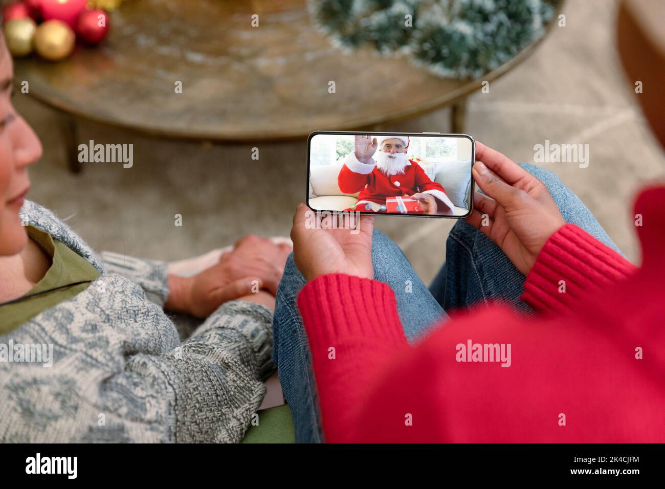Two diverse female friends on christmas video call on smartphone with ...