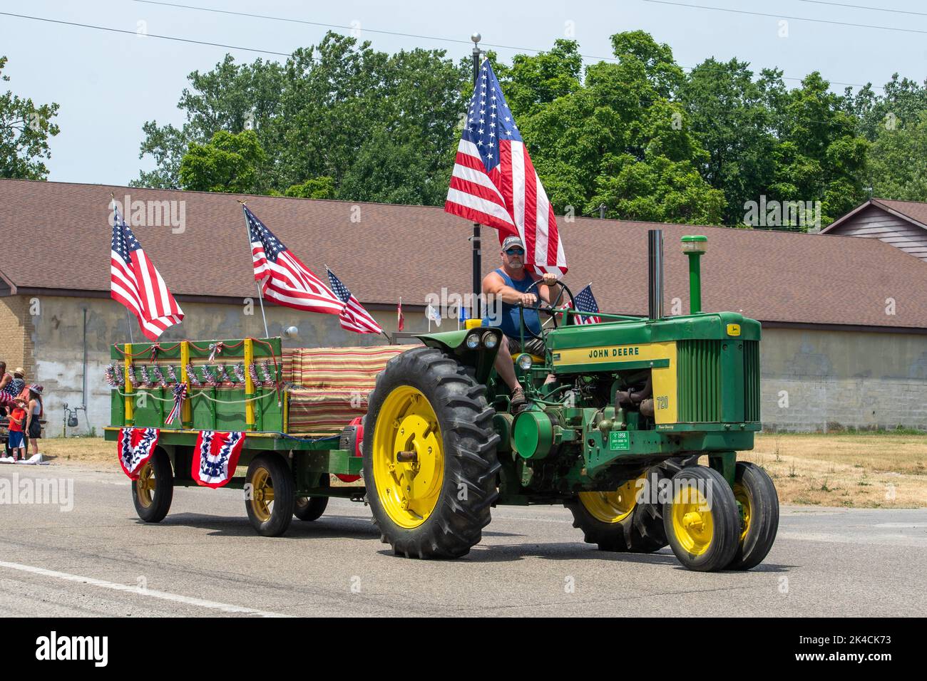 Eau Claire MI USA, July 4 2022; A farmer drives a large green John