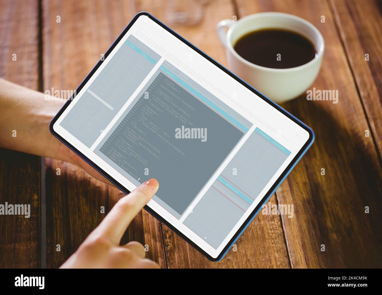 Woman using her tablet pc on wooden table Stock Photo