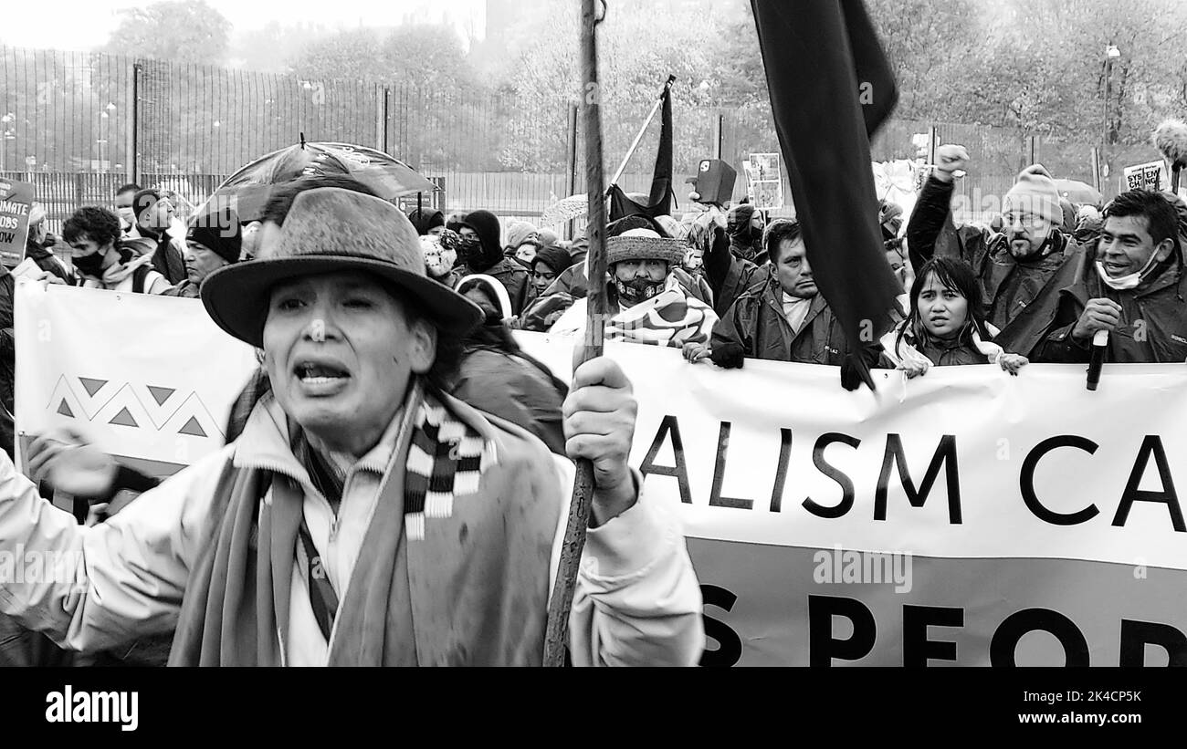 A grayscale shot of a group of angry COP26 protestors marching in the ...