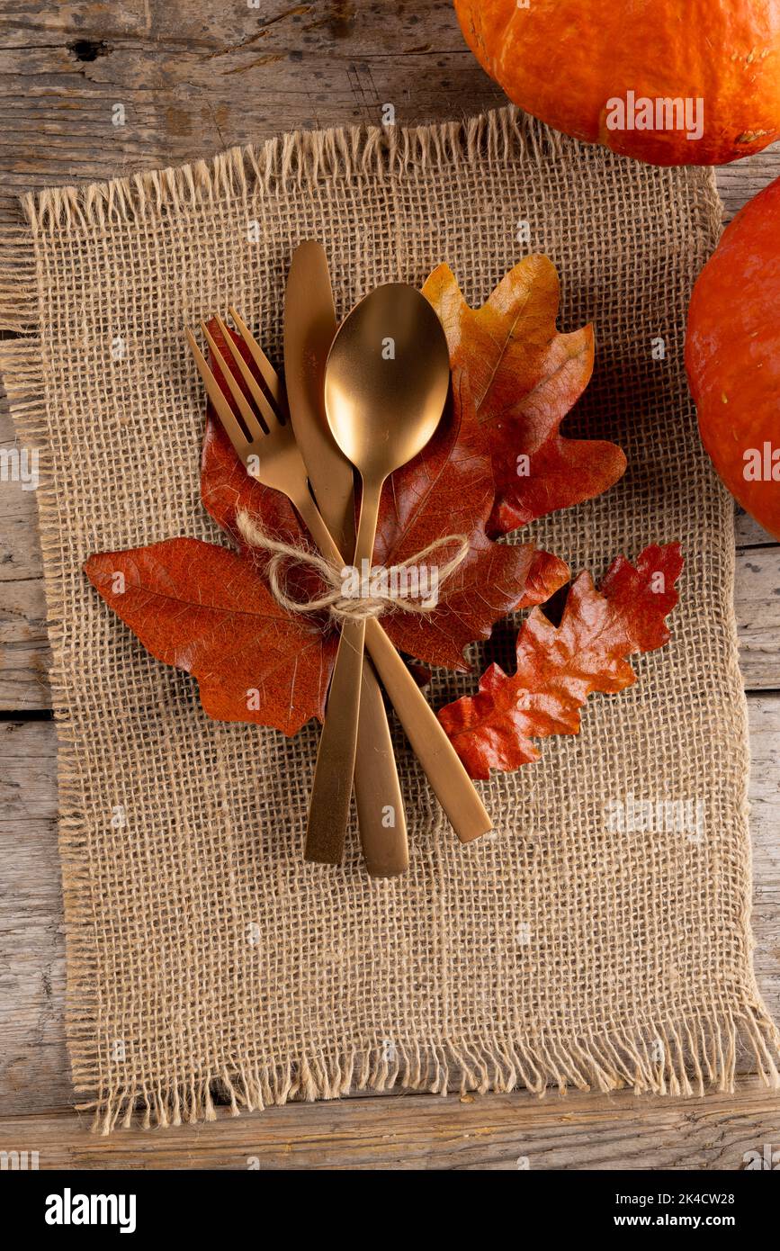 Overhead view of cutlery with autumn decoration and pumkins on wooden background Stock Photo
