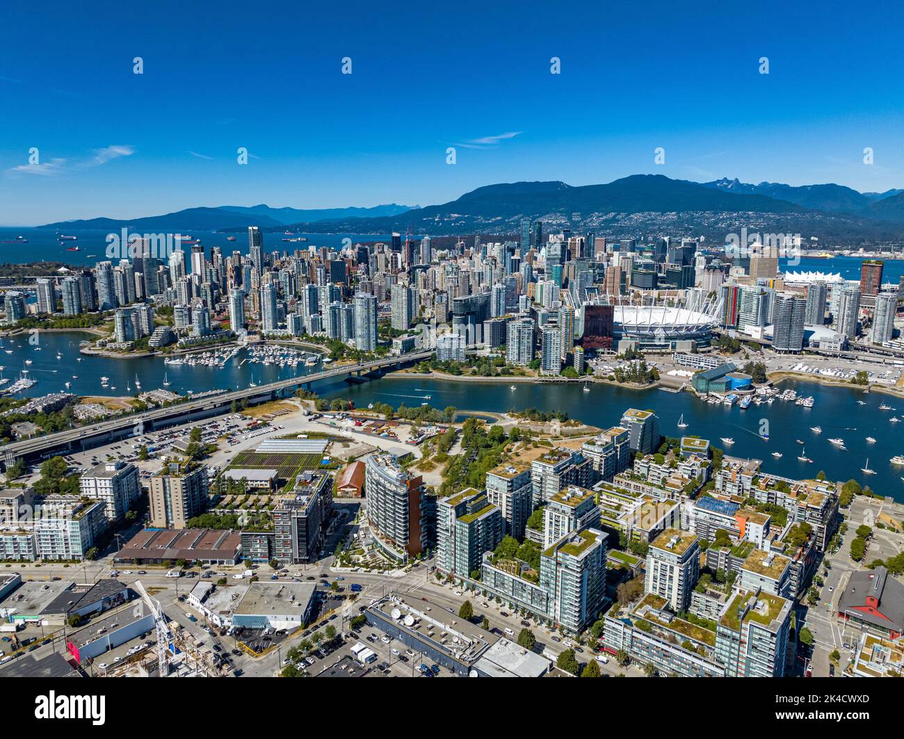 An aerial drone view of downtown of Vancouver with modern buildings under a  blue sky Stock Photo - Alamy