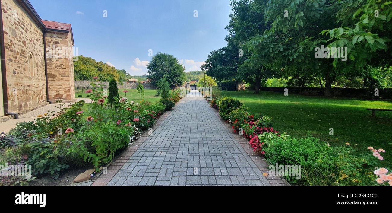 A panoramic shot of an empty pathway by the Mesic Monastery in Serbia Stock Photo