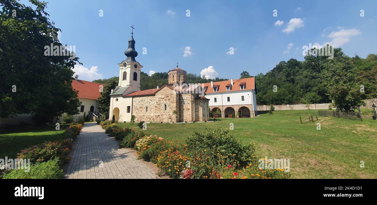 A panoramic shot of the Mesic Monastery in Serbia against a blue cloudy sky Stock Photo
