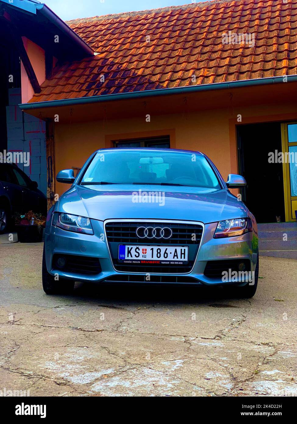 A vertical shot of a silver Audi S4 car on a porch Stock Photo