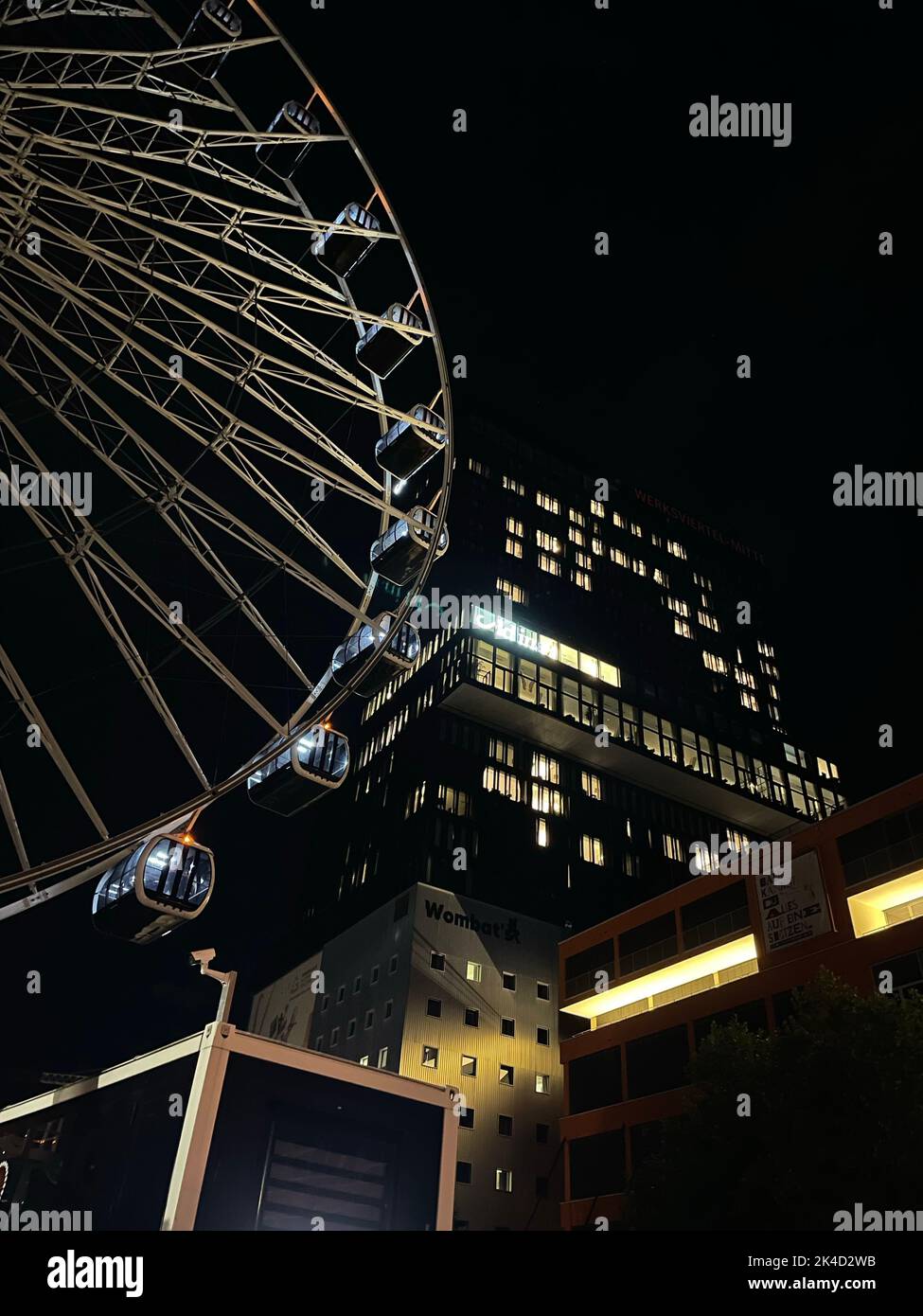a-vertical-shot-of-the-illuminated-werksviertel-mitte-near-a-building