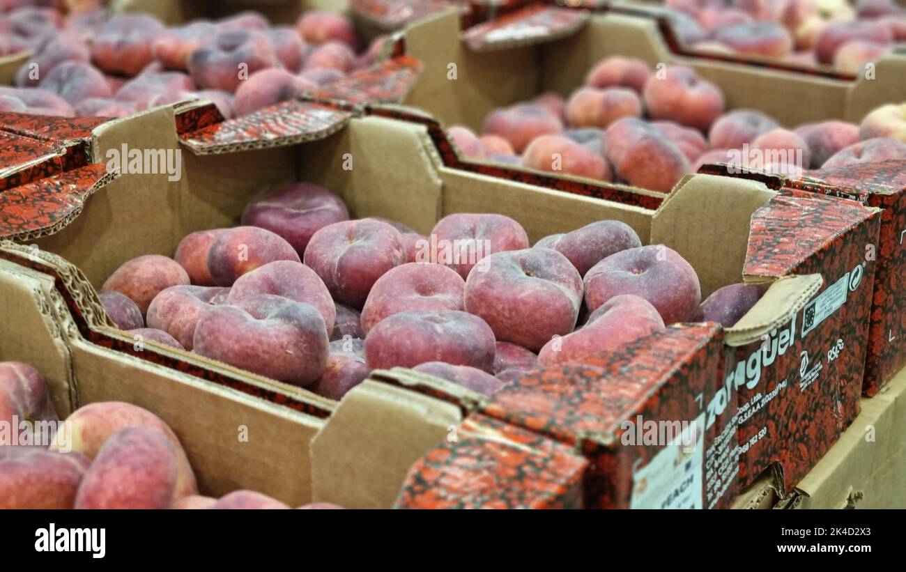 A bunch of flat peaches packed in 5 kilo cardboard boxes Stock Photo
