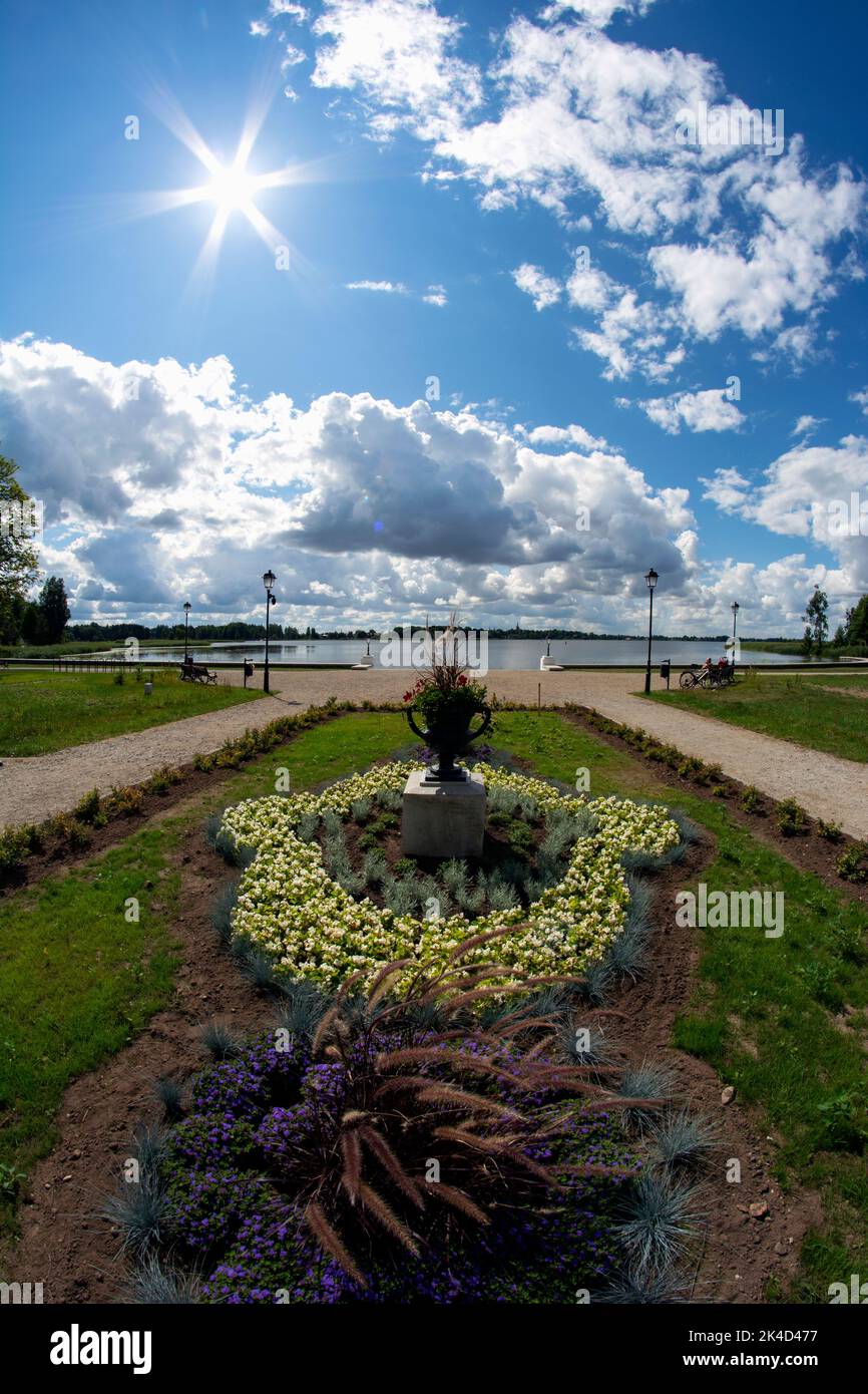 Beautiful summer time flower beds near lake in old manor park, Lithuania, fisheye view Stock Photo