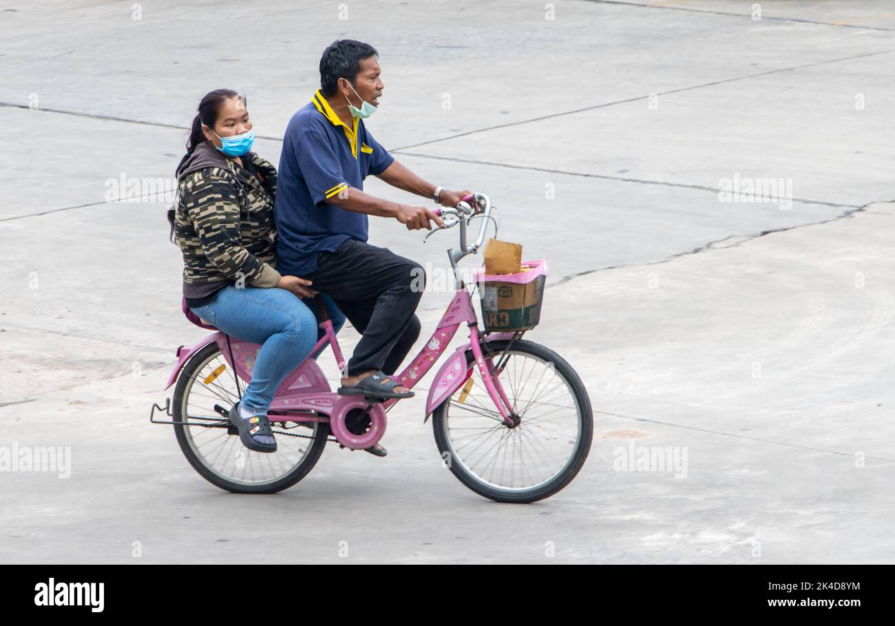SAMUT PRAKAN, THAILAND, SEP 28 2022, A man and a woman ride on the one bicycle Stock Photo