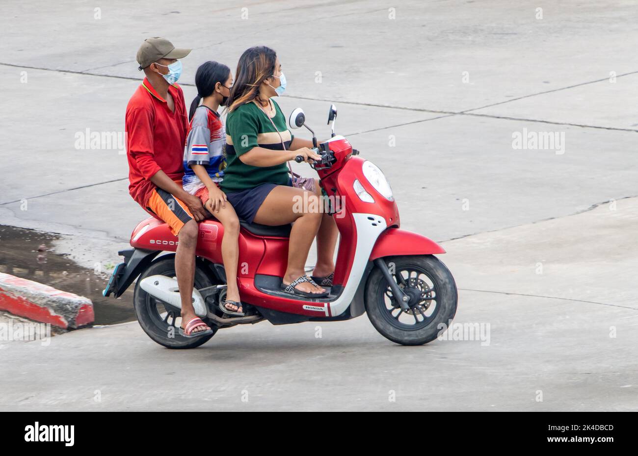 SAMUT PRAKAN, THAILAND, SEP 23 2022, A parents ride a motorcycle with a daughter. Stock Photo