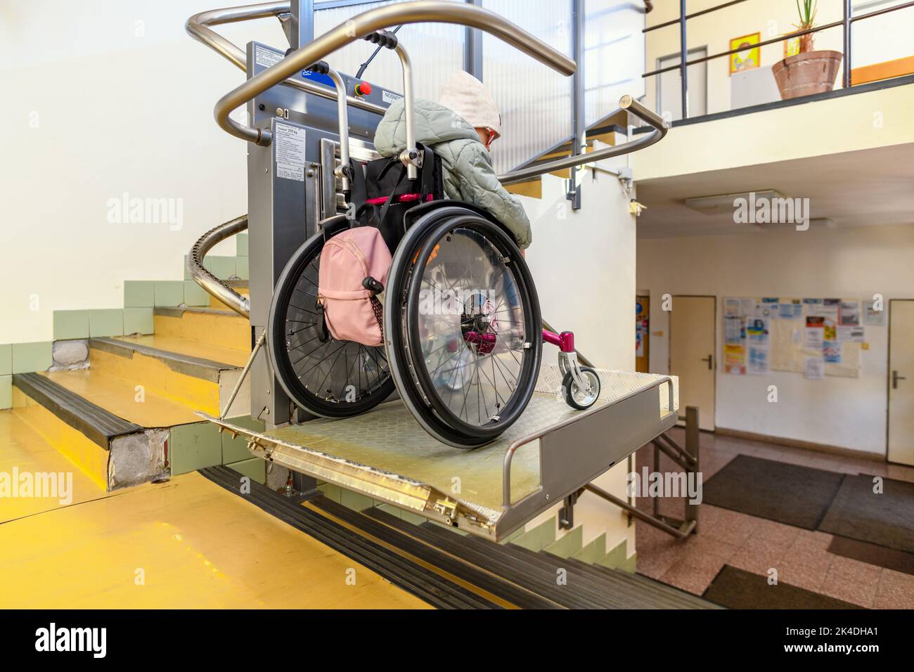 Young child living with cerebral palsy using electric wheelchair lift