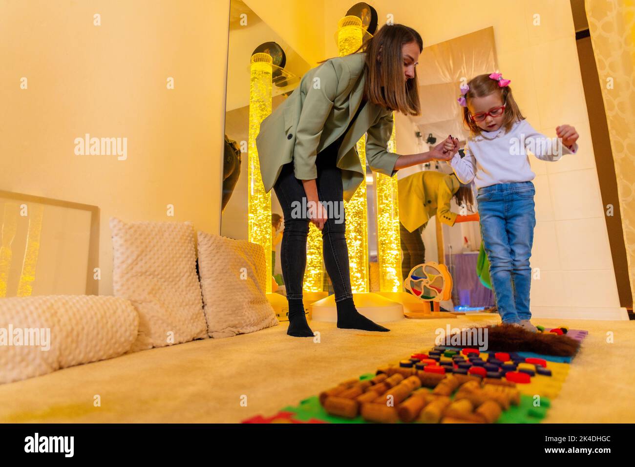 Therapist helping a young child living with cerebral palsy successfully