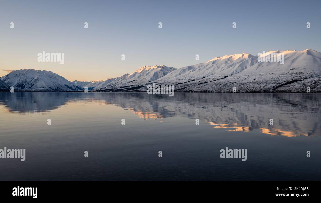 Ben Ohau range reflected in clear water of Lake Ohau at sunset, Twizel ...