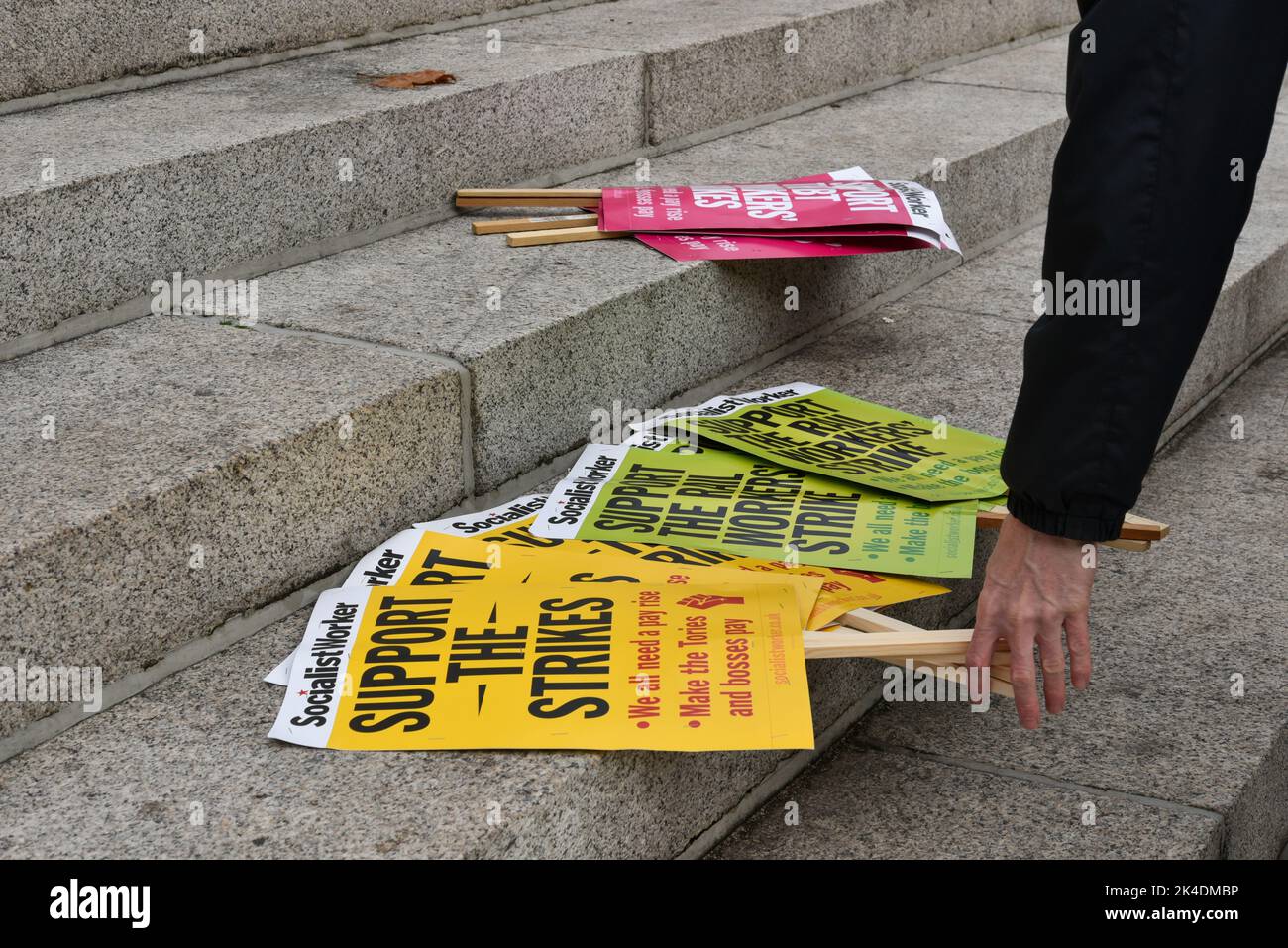 Man picks up a protest signs from a variety of different types at a