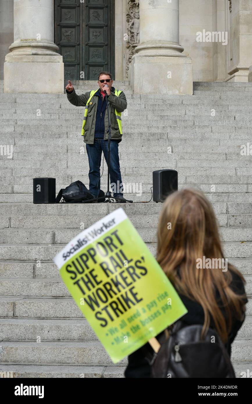 Union representative talks to  protestors who have come together at the enough is enough march in Portsmouth, England.  A woman holds a banner. Stock Photo
