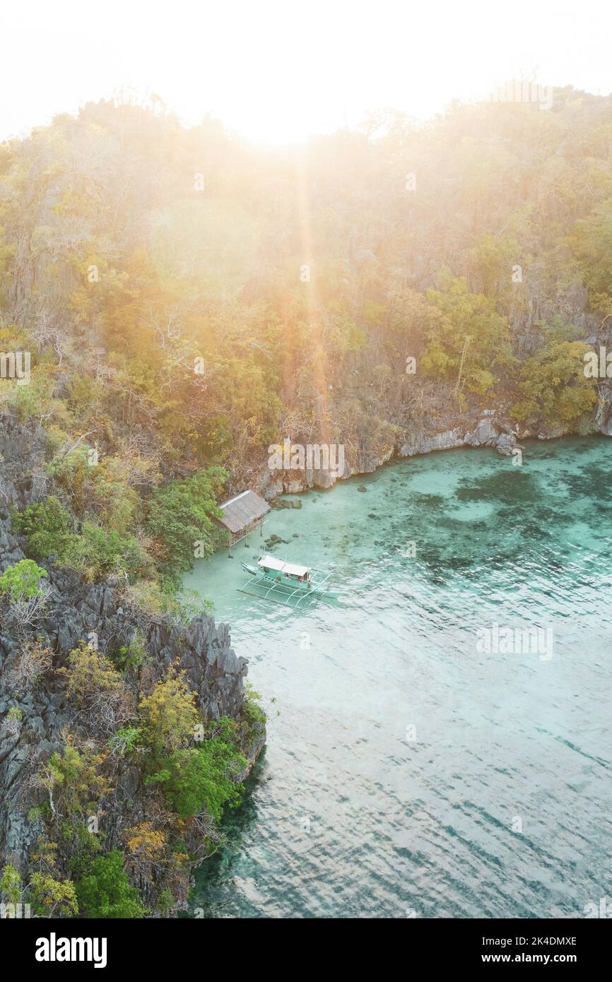 View from above, stunning aerial view of a bungalow on a a turquoise water surrounded by rocky cliffs. Malwawey Coral Garden, Coron Island, Palawan Stock Photo