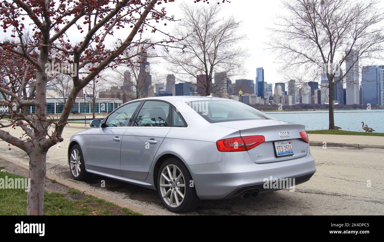 CHICAGO, ILLINOIS, UNITED STATES - DECEMBER 15, 2015: Silver mid-size car with Chicago skyline in background on a winter day without snow Stock Photo