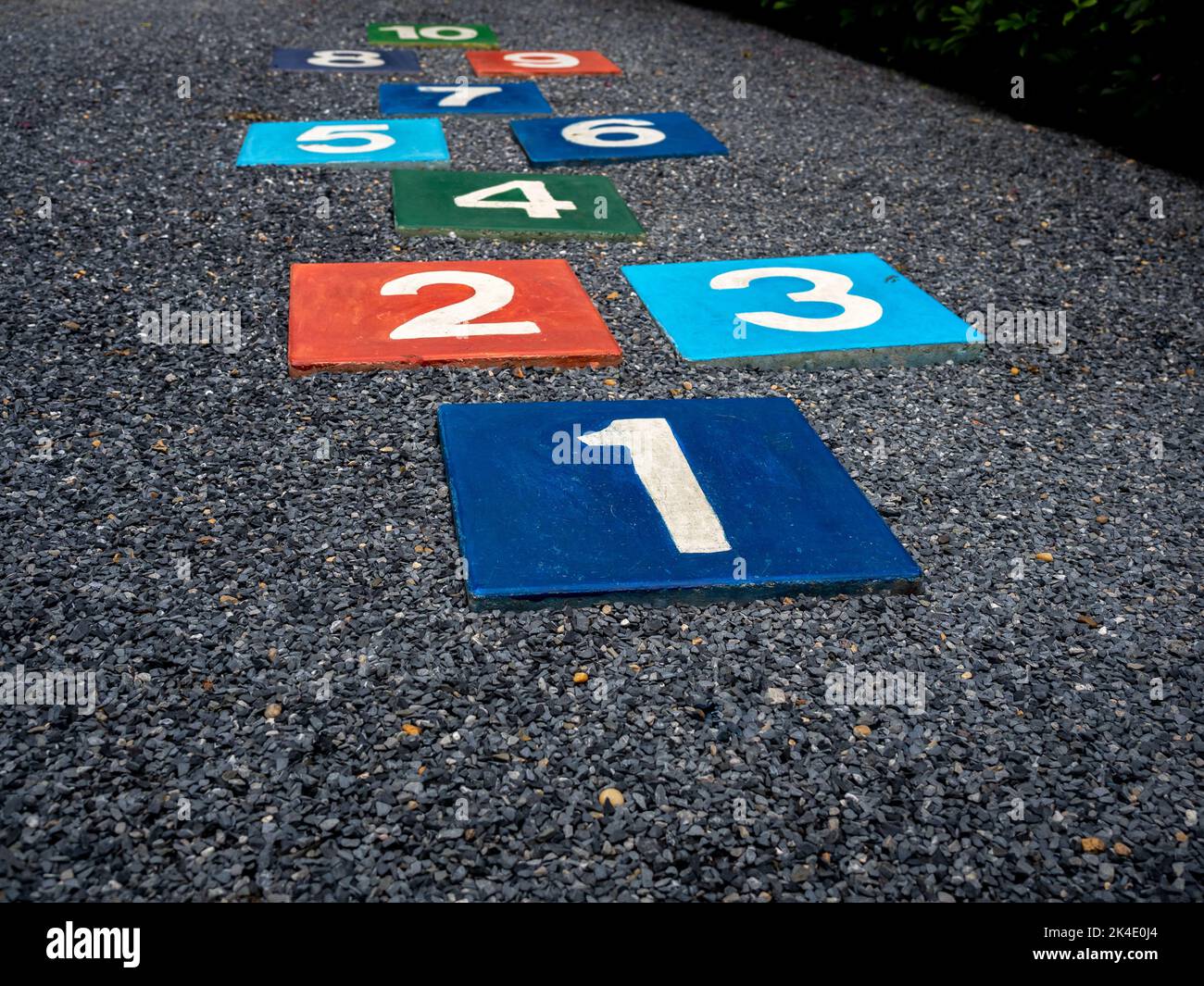 Number 1 on multicolored hopscotch on the asphalt ground in the kids playground with nobody, outdoors game activities for children. Growth and educati Stock Photo