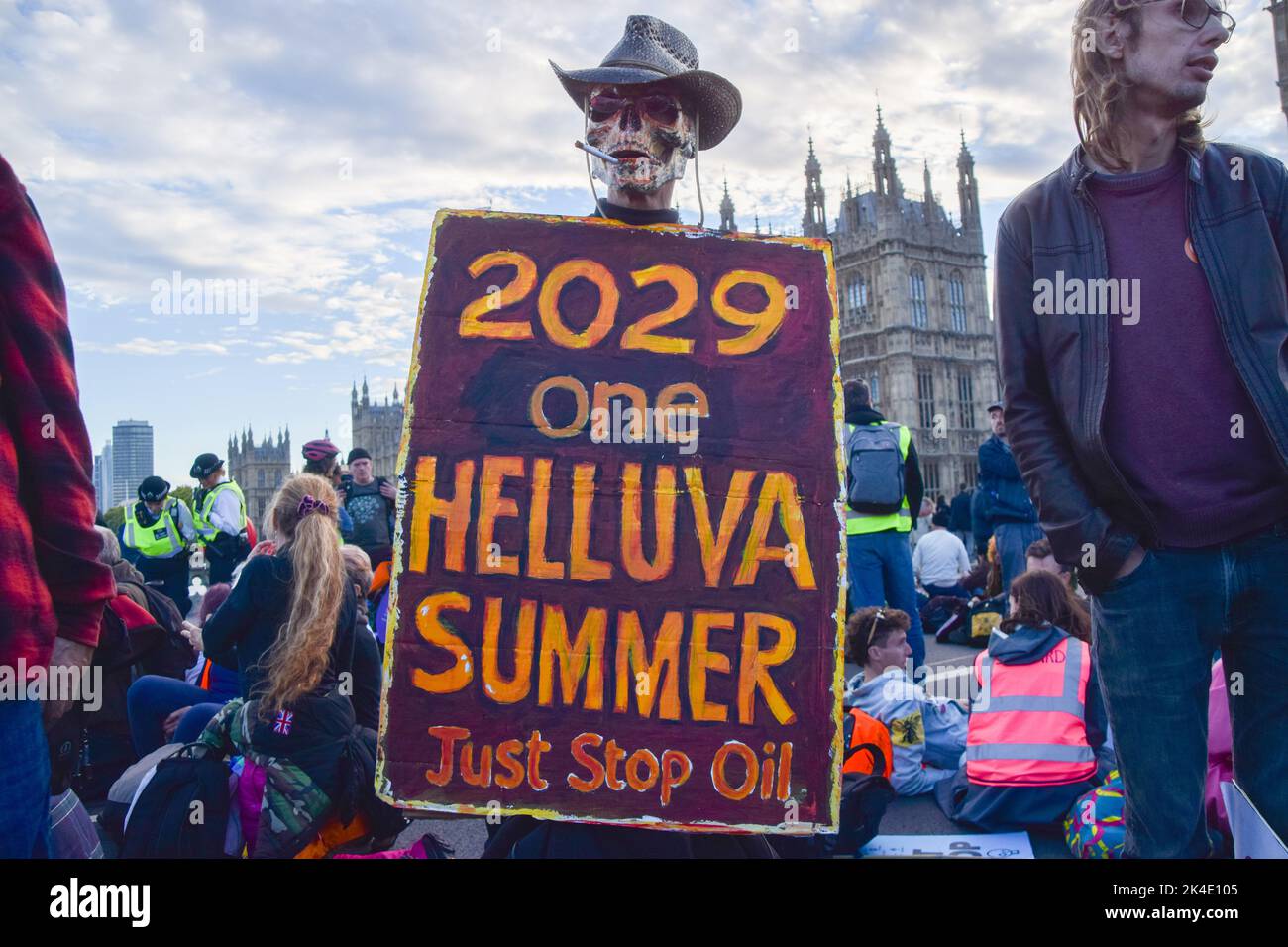 London, UK. 01st Oct, 2022. A protester wearing a skull mask holds a placard which states '2029 one helluva summer' on Westminster Bridge during the Just Stop Oil and Extinction Rebellion march through Central London. The march was part of the day's Enough Is Enough protests which saw various groups come together in protest against the cost of living crisis, rising energy bills, climate change and the Tory Government, and in solidarity with the ongoing strikes around the UK. Credit: SOPA Images Limited/Alamy Live News Stock Photo