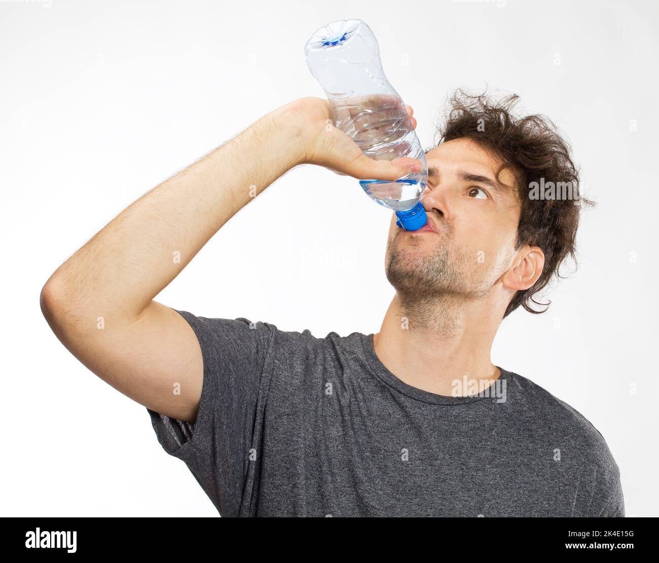 Portrait of cheerful young man drinking water Stock Photo