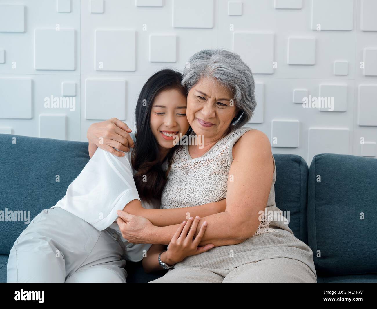 Portrait of happy Asian senior, mother or grandparent white hair embracing her beautiful daughter or grandchild smiling and closing eyes with feel lov Stock Photo