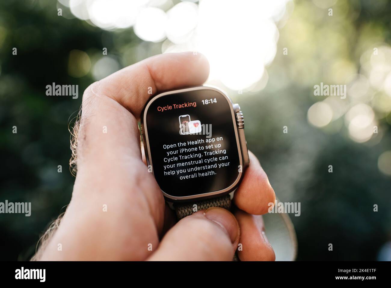 London, United Kingdom - Sept 28, 2022: Hand holding new Apple Computers Apple Watch Ultra wearable in hands looking at the Cycle Tracking app for menstrual cycle to understand overall health Stock Photo