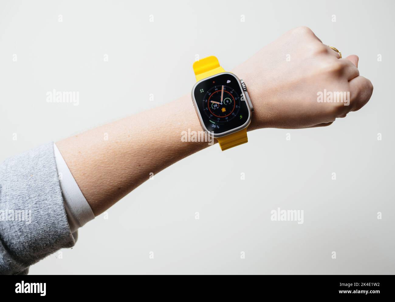 London, United Kingdom - Sept 28, 2022: Powerful woman holding Apple Computers Apple Watch Ultra wearable on her wrist white background Stock Photo