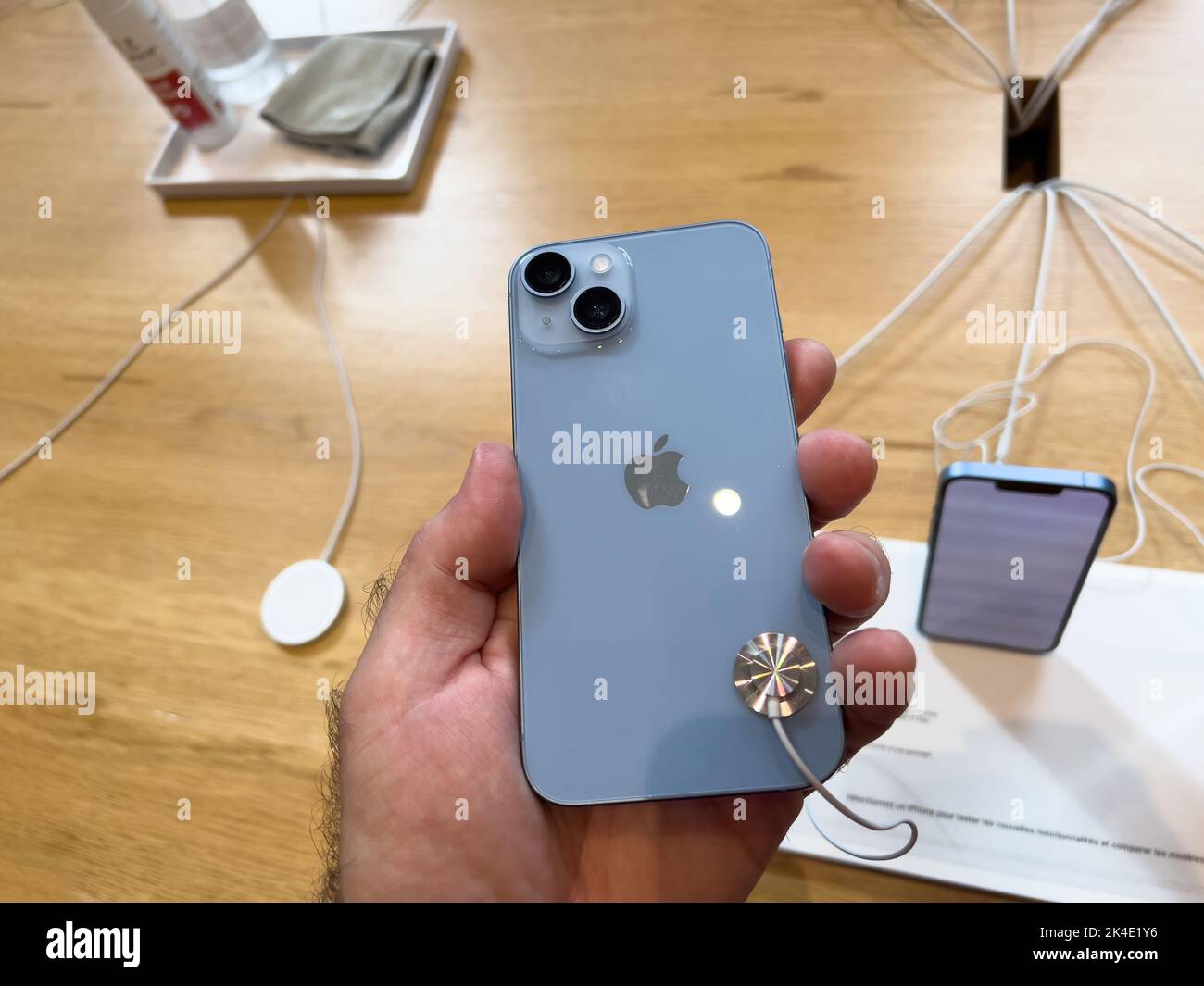 Paris, France - Sep 16, 2022: Customer holding new sky blue colored Apple Computers iPhone 14 during the launch day featuring new dual powerful camera car crash detection and satellite SOS Stock Photo