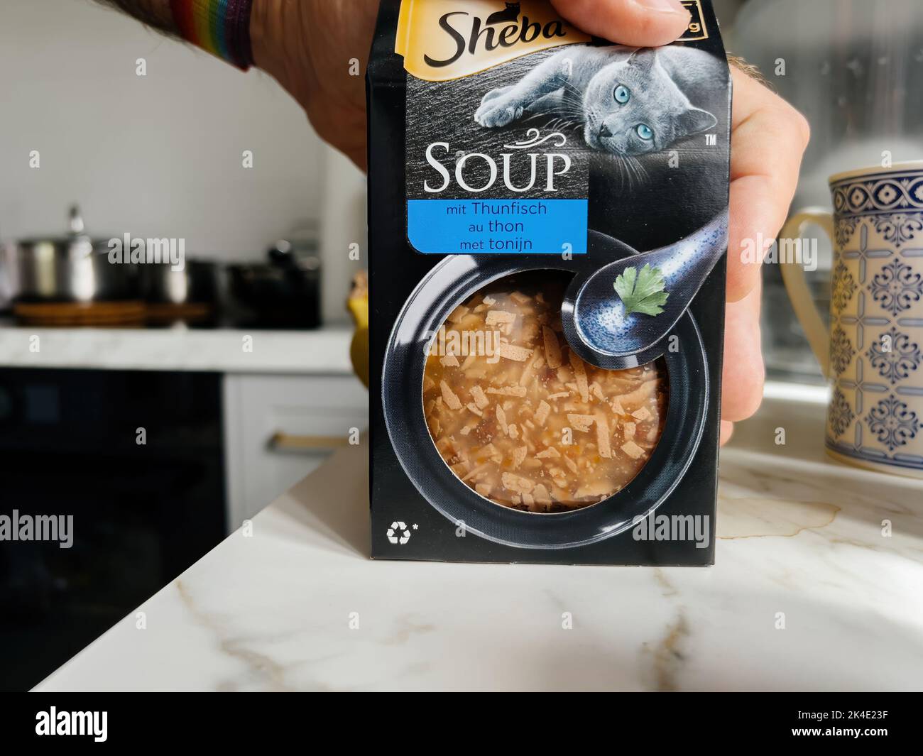 Paris, France - Sep 13, 2022: POV male hand holding carton package with Sheba Soup with tuna fish - modern kitchen background preparing to feed the pet cat animal Stock Photo