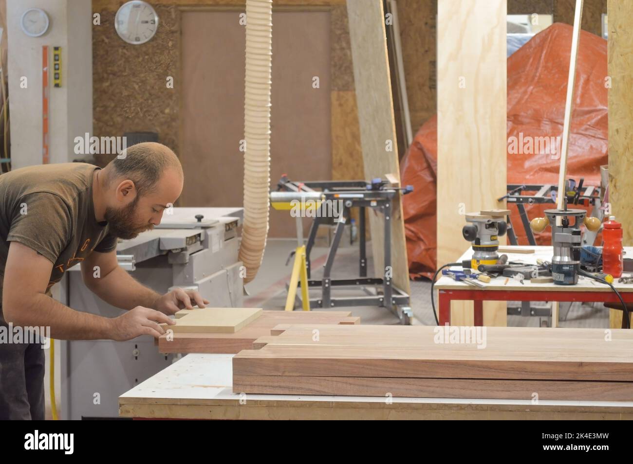 A man cuts wood on a circular saw in a joinery, band saw, holding a ...