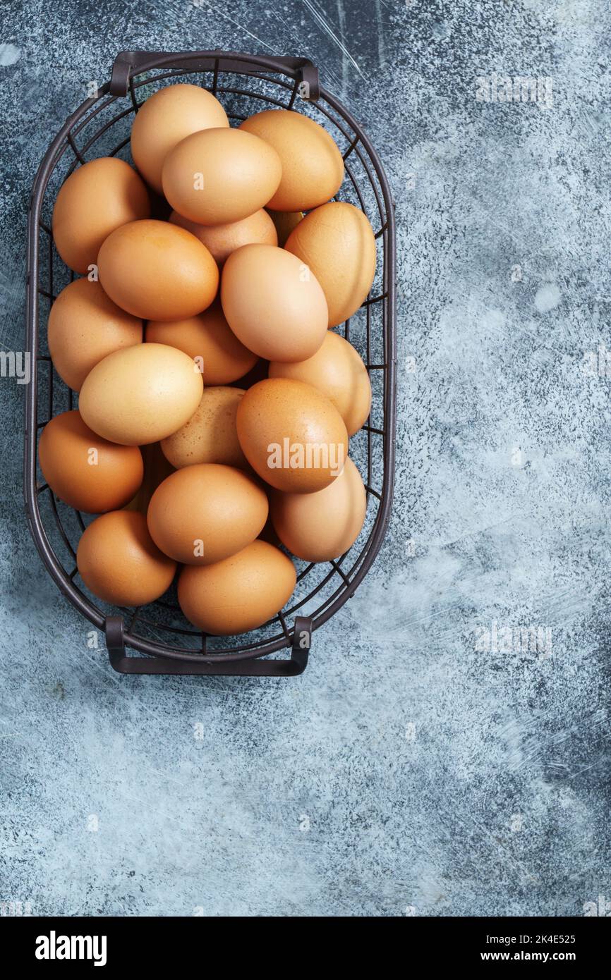 Chicken eggs in metal  basket top view with copy space Stock Photo