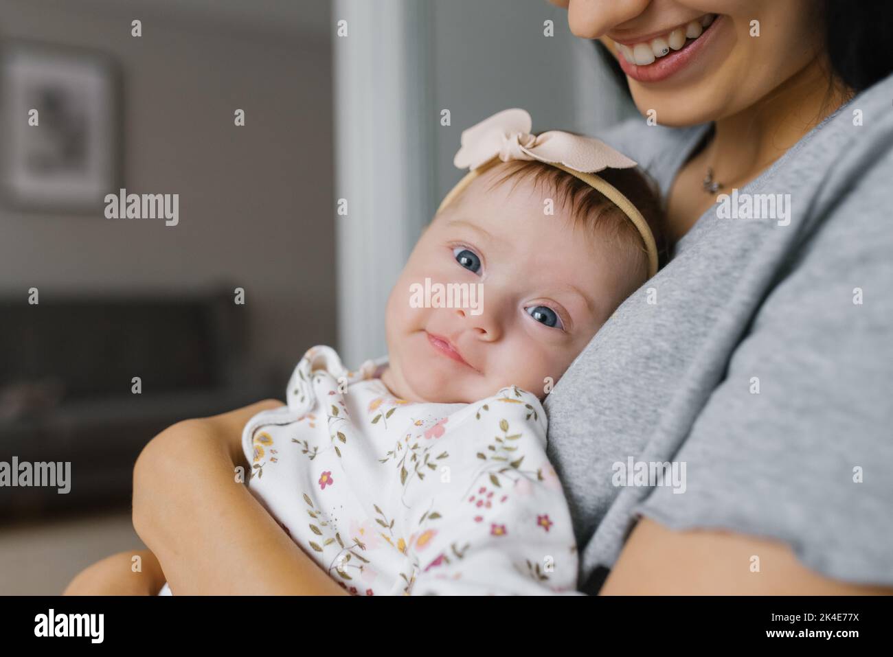 Young woman mom with baby girl on hands at home Stock Photo