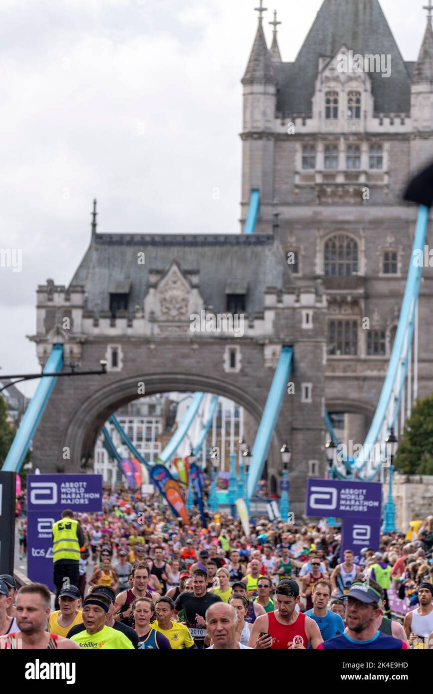 Tower Hill, London, UK. 2nd Oct, 2022. Around 50,000 people are taking part in the 2022 TCS London Marathon, including the world’s top elite runners. Athletes such as Olympic champion Kenenisa Bekele, 2021 men’s winner Ethiopian Sisay Lemma & women’s winner Kenyan Joyciline Jepkosgei are likely to feature at the front. Wheelchair athlete David Weir will also hope for a top place. The mass of club & fun runners are following with many raising large sums for charity & often running in fancy dress. Mass of runners crossing Tower Bridge Stock Photo
