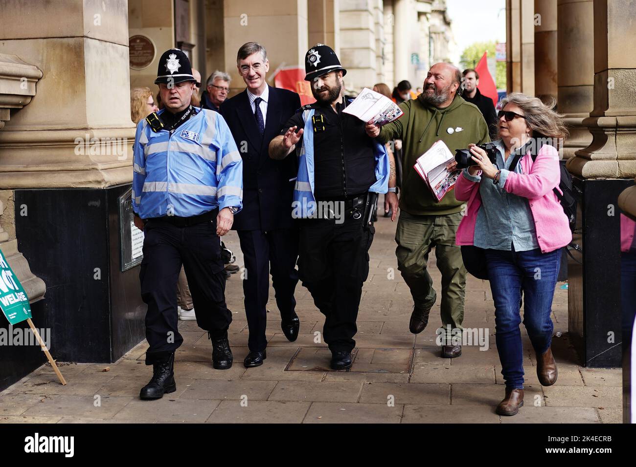 Activists try to hand leaflets to Business Secretary Jacob Rees-Mogg (second left) as he is escorted by police officers at the Conservative Party annual conference at the International Convention Centre in Birmingham. Picture date: Sunday October 2, 2022. Stock Photo
