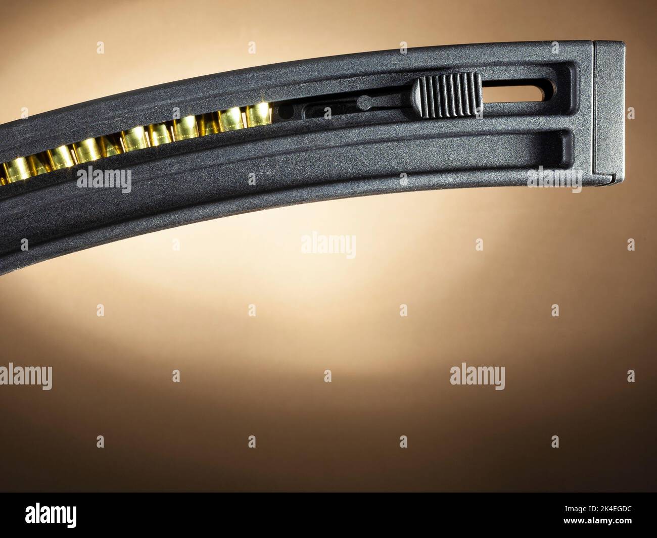 Rifle magazine loaded with rimfire cartridge on a brown background with