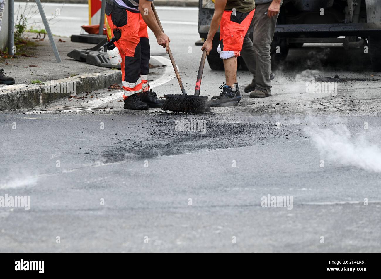 Feet of construction workers paving a road Stock Photo