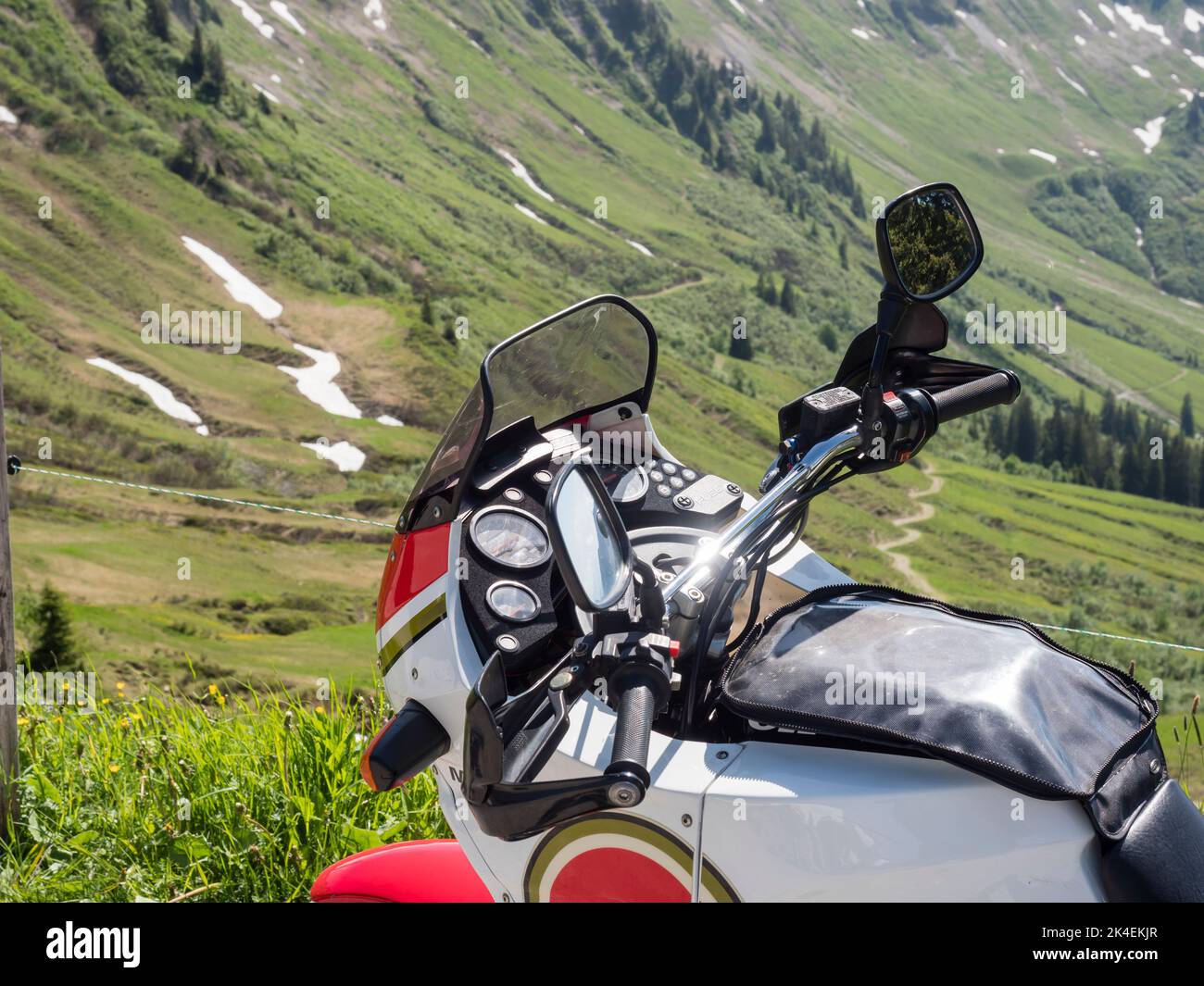 Cockipit of an adventure motorcycle, parked for a break at a pass road in the Swiss alps. Stock Photo