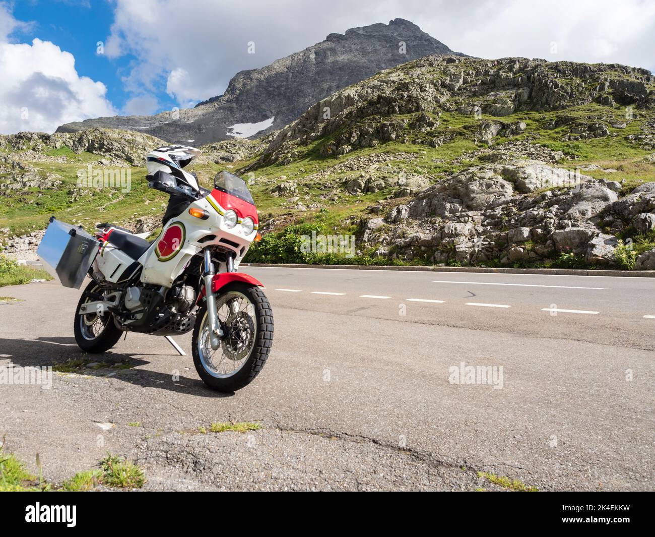 An adventure motorcycle at a mountain pass in the Swiss alps. Stock Photo