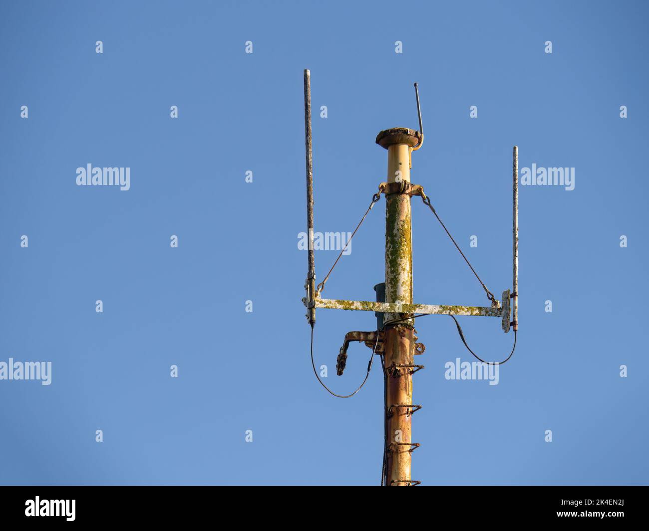 Rusty ship aerials on the mast. Blue sky. Stock Photo