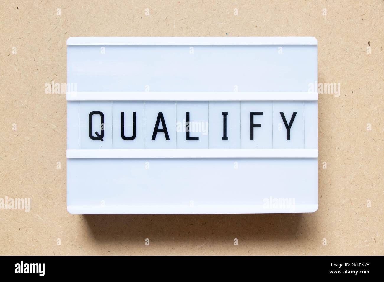 Lightbox with word qualify on wood background Stock Photo