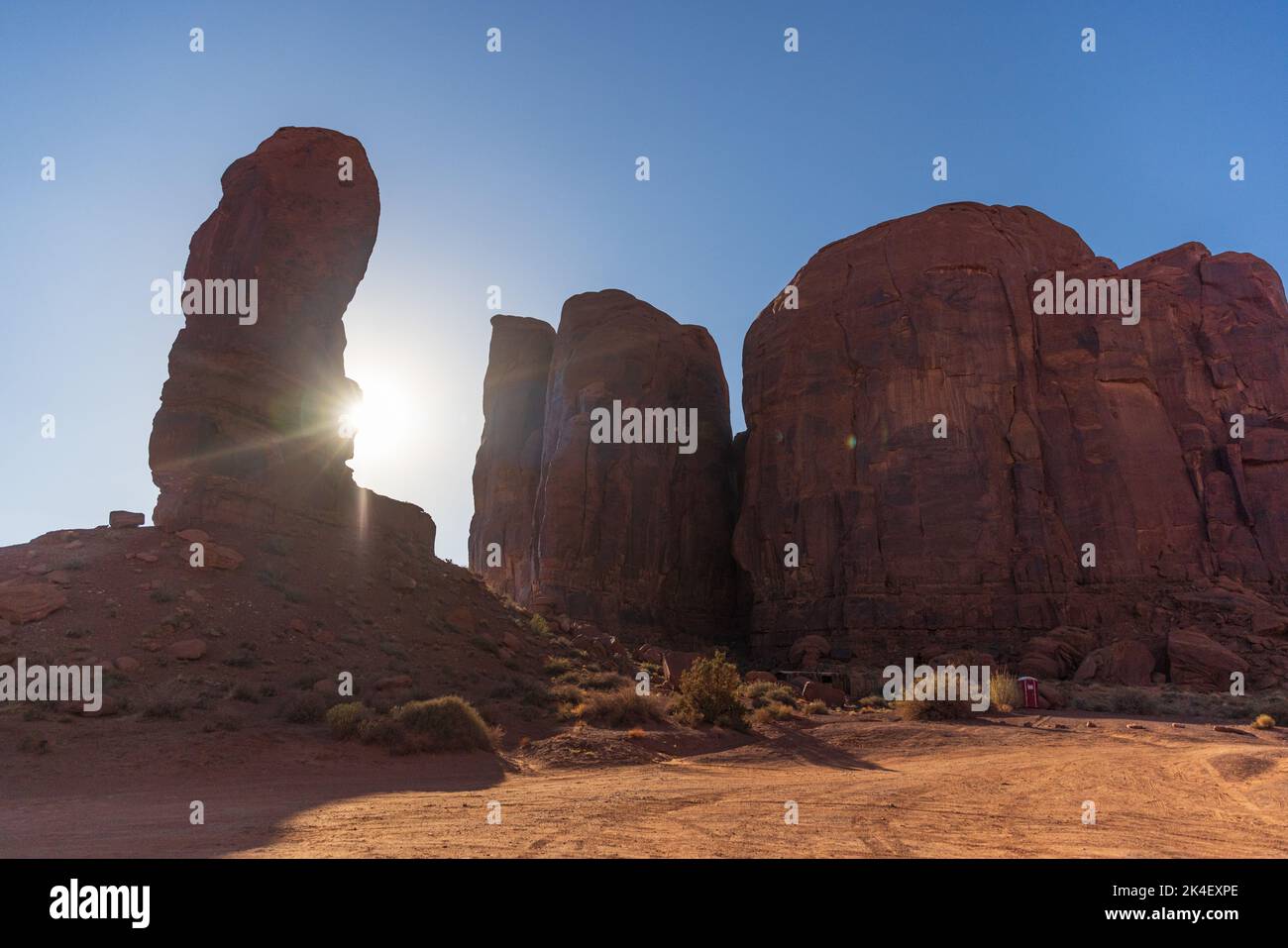 Sun setting behind the thumb rock formation at Monument Valley Stock ...