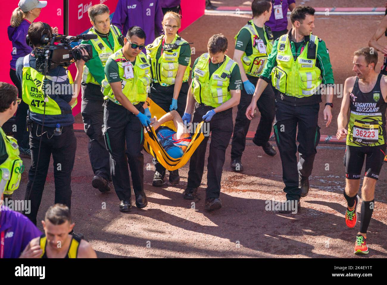 London UK. 2 October 2022 . Marathon runners is carried  on a stretcher by paramedics after crossing the finishing line at The Mall .More than  40,000 athletes including  elite  runners, club runners and fun runners   take  part in the London Marathon sponsored by TCS Tata Consultancy Services over a 26.2 mile course.Credit: amer ghazzal/Alamy Live News. Stock Photo